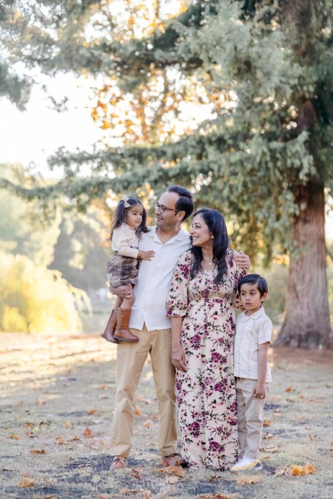 A family of four share smiles during their golden hour fall family photoshoot in bay area