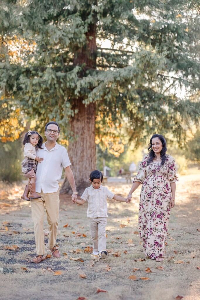 family of four walking hand in hand during a fall family photoshoot during golden hour in Bay Area