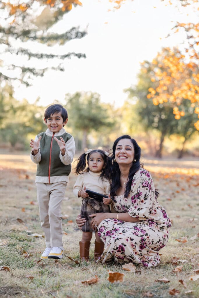 Mom with her kids share a playful moment during their fall photoshoot during golden hour in bay area