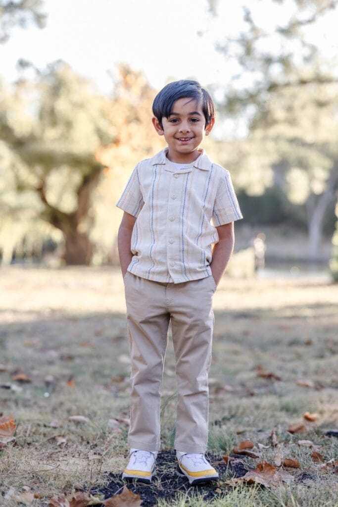 young boy poses during a fall family photoshoot at ed levin county park